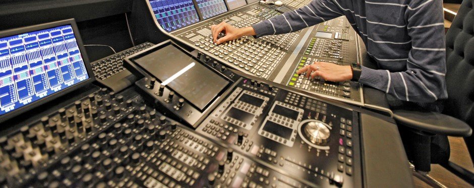 A man works at a mixing desk.